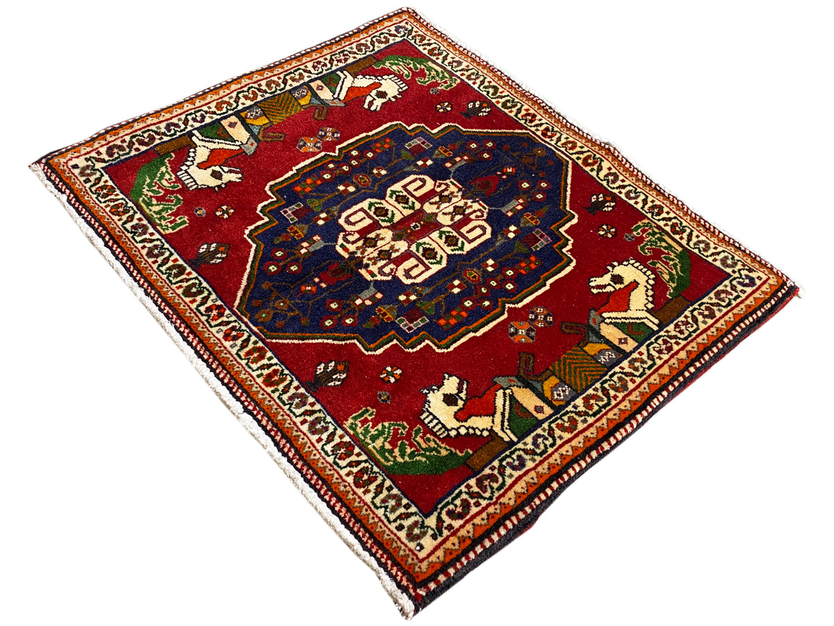 Tapete Poshti em forma de losango, fundo vermelho, medalhão azul e ornamentos de animais