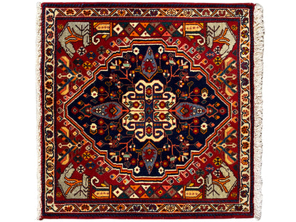 Tapete quadrado com fundo vermelho, estrela azul estampada e bordaduras decorativas
