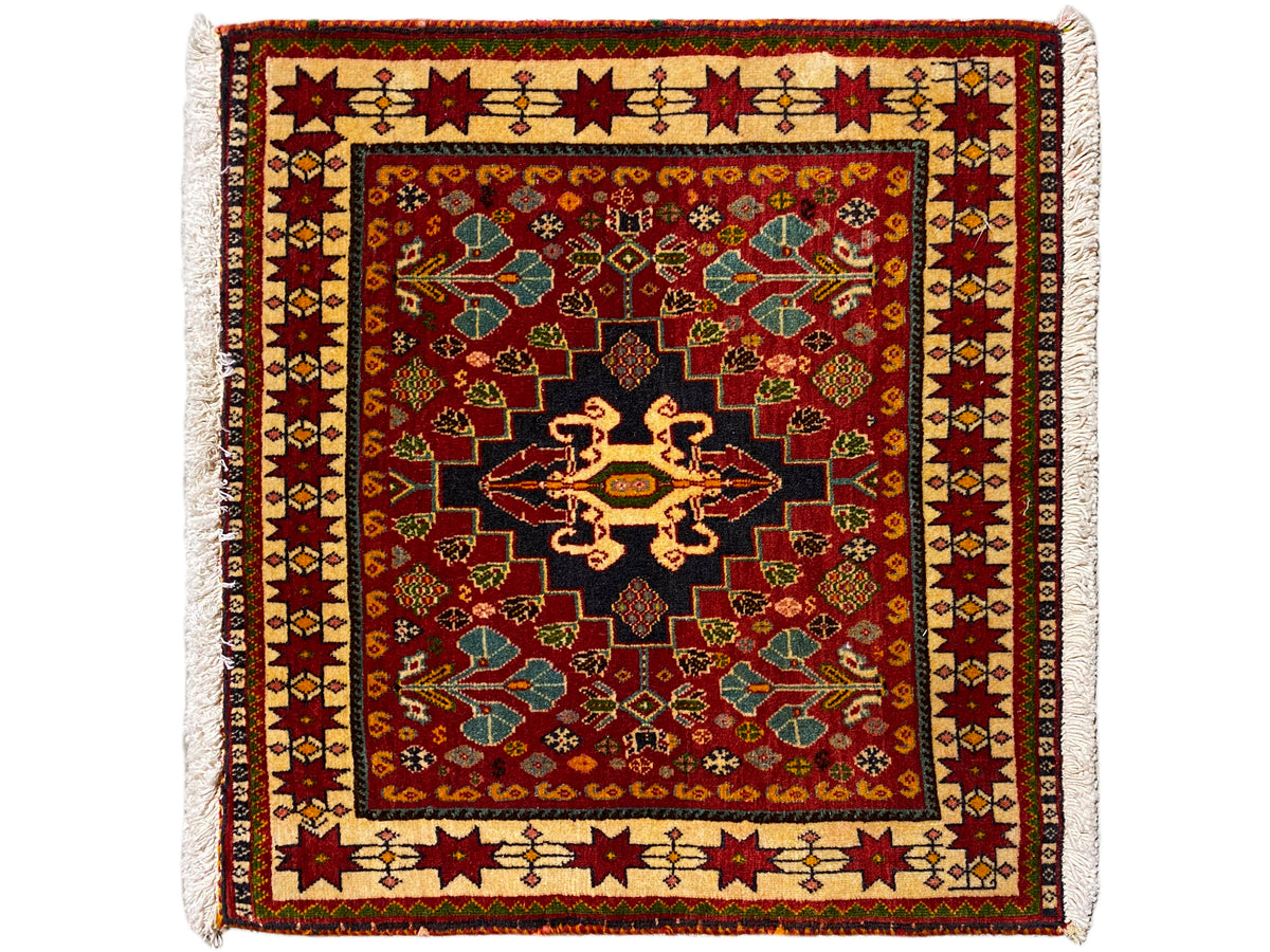 Tapete 60x58 cm: ornamento vermelho, centro preto, rebordo colorido, franjas