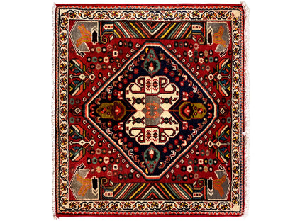 Tapete oriental com fundo vermelho, medalhão azul-escuro e ornamentos geométricos