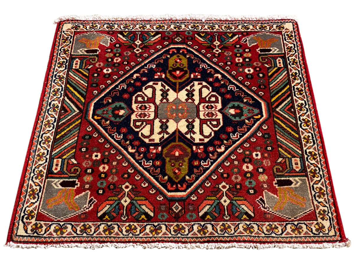 Tapete orientalista retangular com padrão vermelho, moldura interior azul e ornamentos nas margens