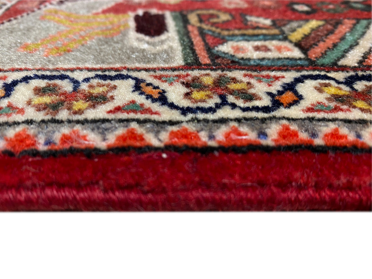 Grande plano: orla de tapete com franjas, acabamento vermelho e padrão ornamental denso