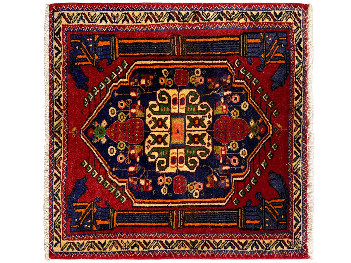 Tapete Poshti 66x62 cm com medalhão central vermelho e ornamento de canto azul.