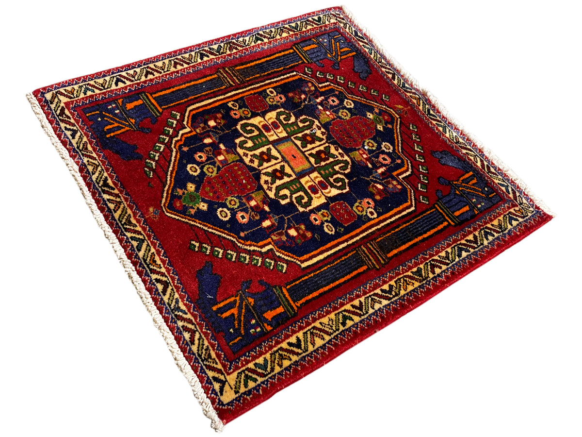 Tapete Poshti 66x62 cm na diagonal: borda azul e vermelha com numerosos ornamentos.