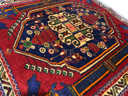Tapete Poshti 66x62 cm Detalhe: motivo central vermelho, campo azul e linhas decorativas coloridas.