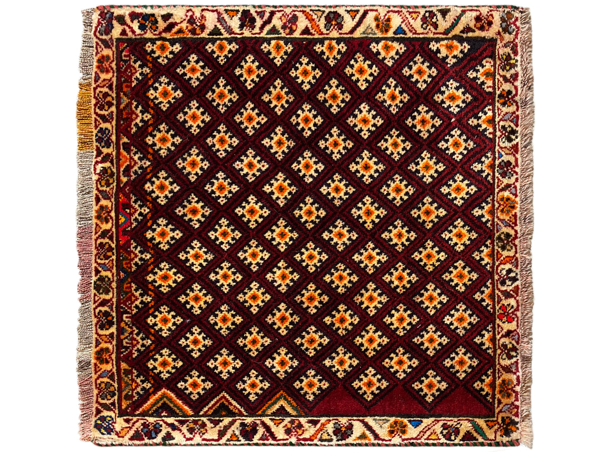 Tapete Poshti 61x59 cm: quadrado, com padrão geométrico de losangos em vermelho-escuro com apontamentos coloridos