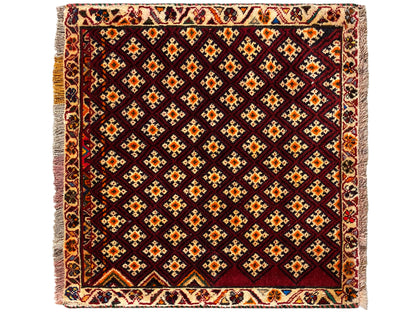 Tapete Poshti 61x59 cm: quadrado, com padrão geométrico de losangos em vermelho-escuro com apontamentos coloridos