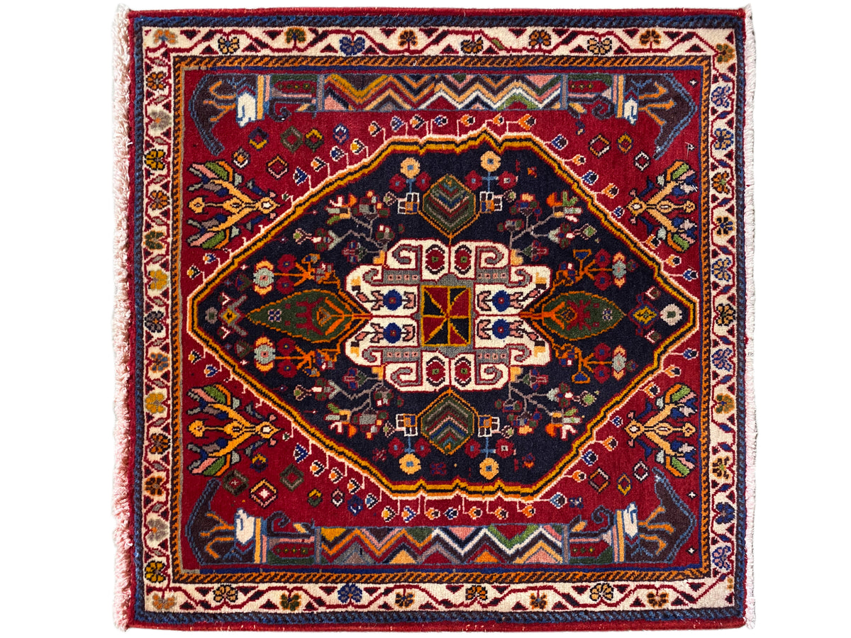 Tapete Poshti (67×67 cm) com composição de medalhões múltiplos, azul-escuro e vermelho