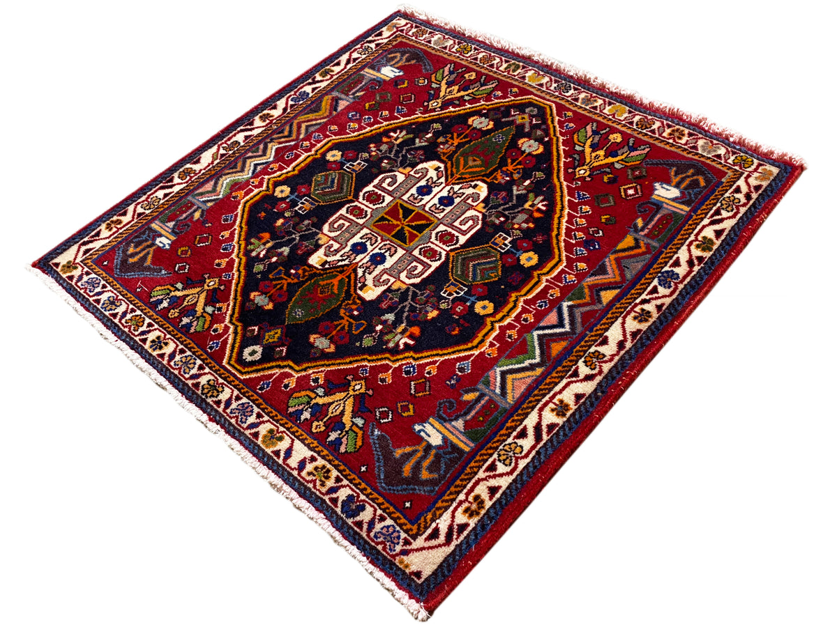 Tapete Poshti (67×67 cm) na diagonal: bordadura castanho-avermelhada, campo azul com ornamentos