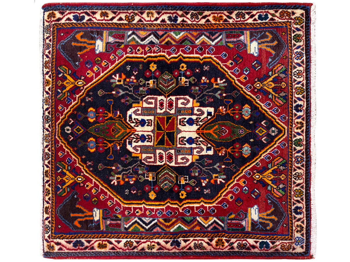Tapete quadrado com fundo azul-escuro, moldura vermelha e ornamento centrado, 70x67 cm