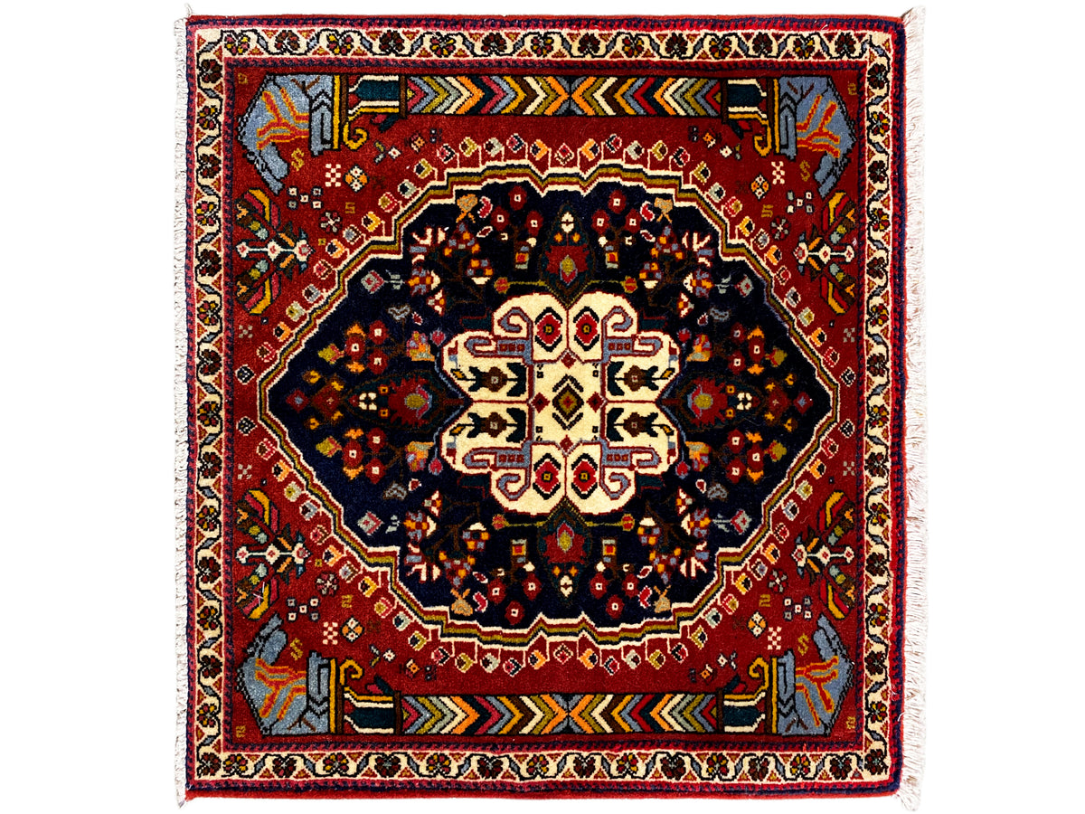 Tapete Poshti 65x61 cm com borda vermelha, motivo central escuro e ornamentos coloridos