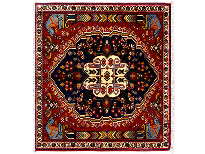 Tapete Poshti 65x61 cm com borda vermelha, motivo central escuro e ornamentos coloridos